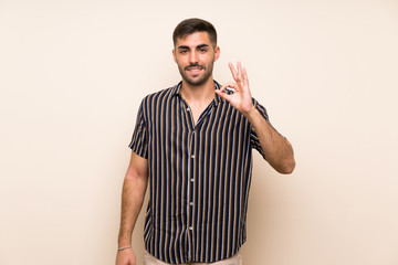 Fototapeta premium Handsome man with beard over isolated background showing an ok sign with fingers