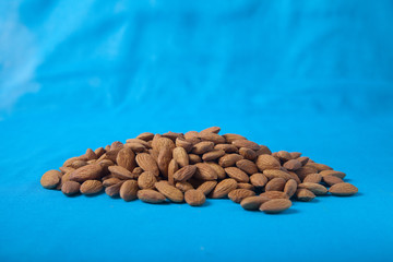 Almonds on a blue background. Copy spais. horizontally.