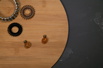 Wooden tray on a gray background with different feminine baubles