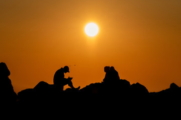 Fototapeta na wymiar Silhouettes of people at sunrise at the Black Sea