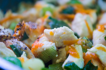 preparation of home diet dishes of white chicken meat with carrots, onions and spices, close-up