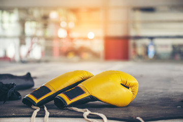 Boxing leather mitt glove and Headquard placed on canvas of ring in camp of training boxer.Equipments for protection during heavy sparring sessions,Used for Muay Thai, Kick Boxing and MMA Training