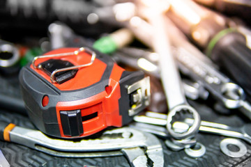Wrench set and tape measure on the tray in car repair garage. Fixing tools or mechanical equipment for automobile industry concept