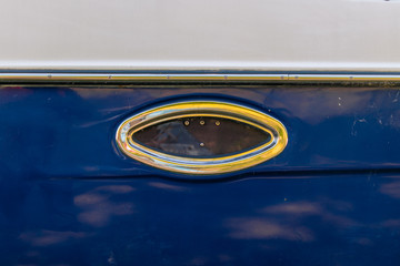 Board with porthole of an old blue ship