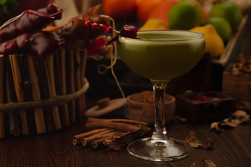 Beautiful cocktail in the chalet on a wooden background. Background decorated with fruits and herbs.