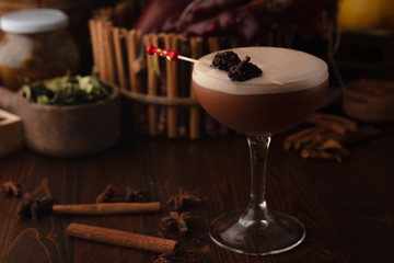 Beautiful cocktail in the chalet on a wooden background. Background decorated with fruits and herbs.