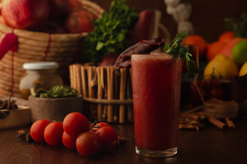 Cocktail Bloody Mary on a wooden background. Background decorated with fruits and herbs.