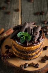 Chocolate cakes on black slatter board with mint, coffee beans on dark background, closeup photo. Fresh, tasty dessert food concept.
