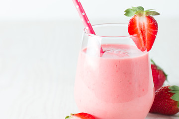 A glass of fresh strawberry smoothie on a wooden background. Summer drink shake, milkshake, juice and refreshment organic concept.