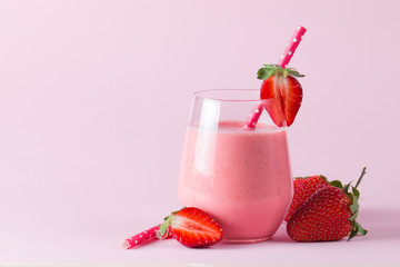 A glass of fresh strawberry smoothie on a wooden background. Summer drink shake, milkshake, juice and refreshment organic concept.