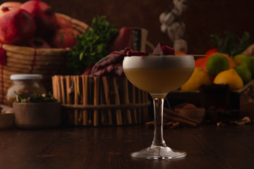 Beautiful cocktail in the chalet on a wooden background. Background decorated with fruits and herbs.