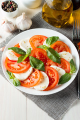 Close-up photo of caprese salad with ripe tomatoes, basil, buffalo mozzarella cheese. Italian and Mediterranean food concept. Fresh and healthy organic meal. Starter and antipasti.