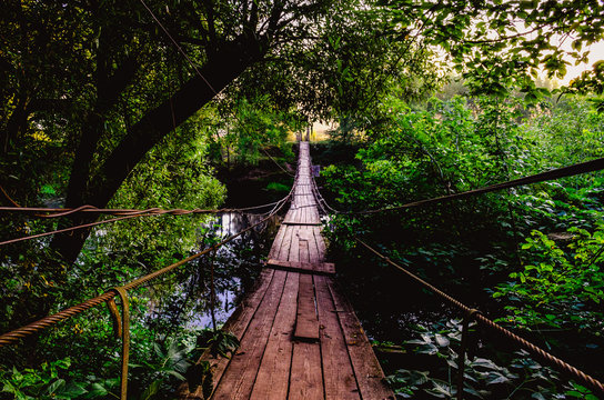 Fototapeta A wooden bridge extending to the other side of the river.