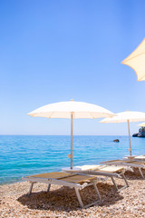 White umbrella and sunbeds at tropical beach