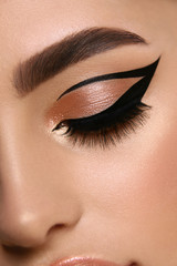 luxury female make-up close-up with eyeliner and golden eye shadow - obrazy, fototapety, plakaty
