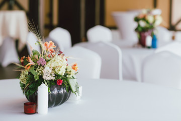 Bouquet of different flowers in a vase on table, preparing for event, wedding