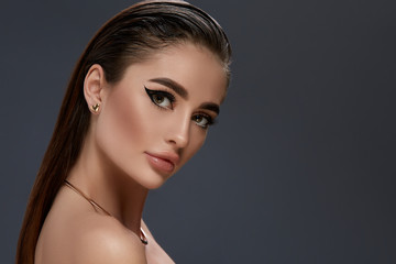 sexy girl with black make-up and golden jewelry looking to the camera