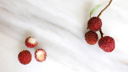 Pulasan fruits on marble bakcground. Scientific name Nephelium ramboutan-akea, pulasan is a red...