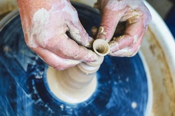 Production of clay products on a potter's wheel. Potter's hands at work_