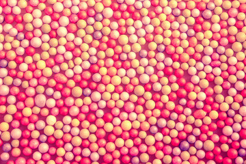 small multicolored foam balls in pink tones. abstract background