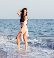 Close up portrait of beautiful young woman on the beach. Young woman model on the seashore. Summer time concept.