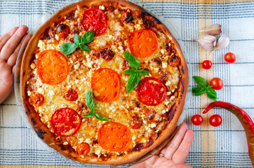 Pizza Margherita with yellow, red and cherry tomatoes, mozzarella cheese, ricotta and fresh basil. Thin vegetarian pizza