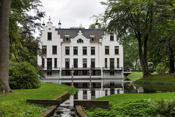 Fototapeta na wymiar Castle Staverden reflecting in the moat and surrounded by trees