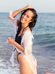 Close up portrait of beautiful young woman on the beach. Young woman model on the seashore. Summer time concept.