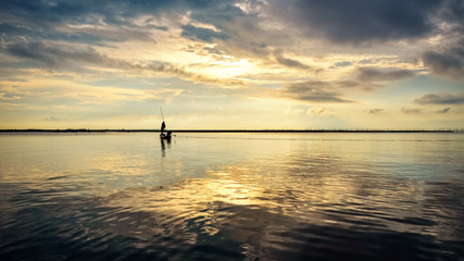 Fisherman on the boat use fishing nets at sunrise, Thailand