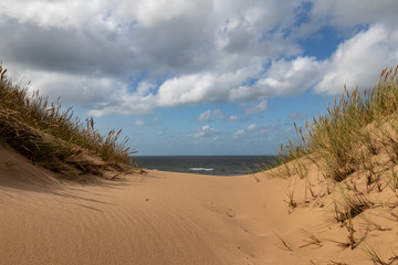 Fototapeta na wymiar Sylt, Dünen, Strand, Meer Wellen und Wolken