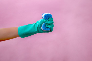Hands of woman wearing gloves prepared to wash dishes with a sponge