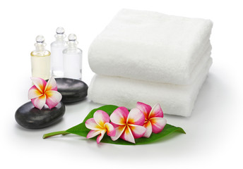 Fototapeta na wymiar tropical spa resort concept; plumeria, hot stones, towels, and massage oils