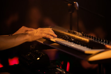Professional pianist playing live set on stage with keyboard synthesizer