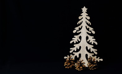 Carved vintage Christmas tree and fir cones in minimal style, black background. Symbolic concept - Christmas, New Year, gifts, symbol.