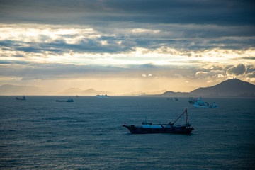 Naklejka premium Fishing boat on sea in sunset lights in Sanya, Hainan, China