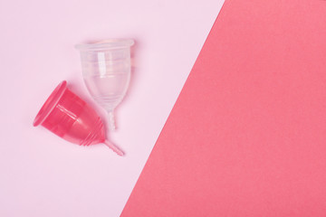 Two menstrual cups close-up on a pink background