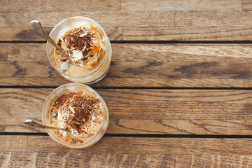 Two affogato in glass on a wooden table