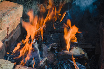 Close-up flame in a makeshift barbecue made of bricks.