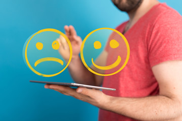 Hand is selecting a happy mood smiley. In front of an empty room