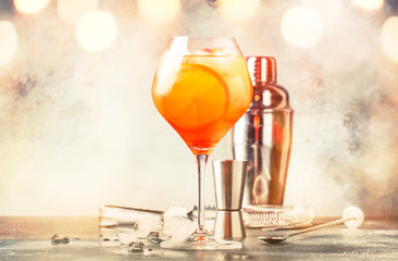 Aperol spritz cocktail in big wine glass with orange and ice, summer alcoholic cold drink, dark bar...