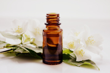 Jasmine oil or essence in a glass bottle for hair and skin. Aromatherapy and Spa concept
