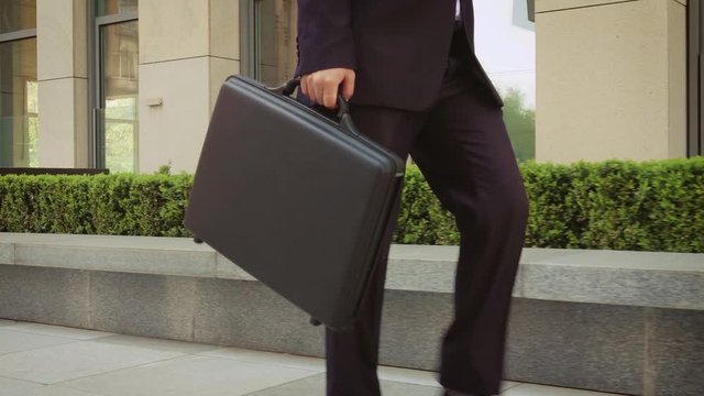 Businessman with a briefcase Walking on Streets of Business District. Close up.