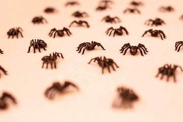 background of many black tarantulas walking on sepia-toned background.