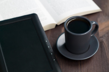 dark cup of coffee and black notebook on a wooden table