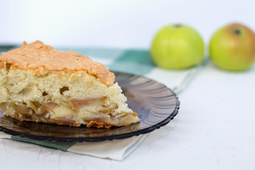 slice of apple pie. apple pie on a dark glass plate with fresh fruits on white background
