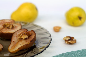 baked pears with nuts and honey on dark glass plate with fresh fruits and nuts white background