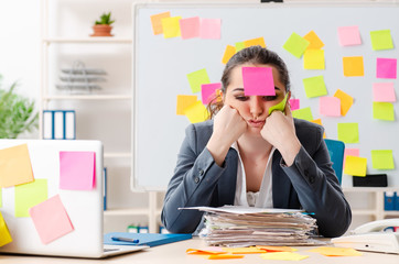Young female employee in conflicting priorities concept