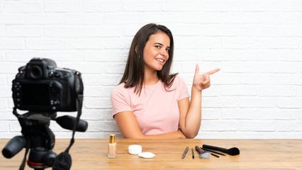 Young girl recording a video tutorial pointing finger to the side