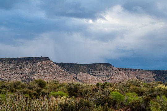 Lava bed topped plateaus under a cloud storm at Snow Canyon State Park in Utah
