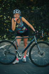 Fototapeta na wymiar Photo on side of young woman in helmet on bike ride on summer day